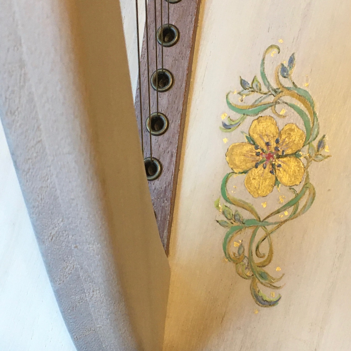 金の花が描かれた白いハープ